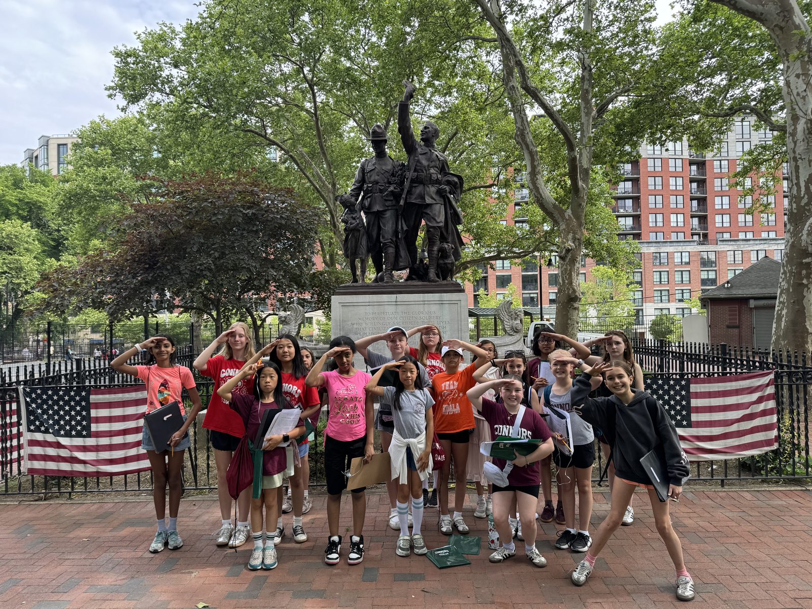 Fifth graders saluting at a Revolutionary War statue during the Hoboken scavenger hunt